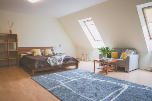 a bedroom with a bed and a couch and a rug at Apartamenty przy Zamku in Olsztyn