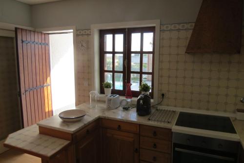 kuchnia z blatem, umywalką i oknem w obiekcie Casa Gaivina 1 w mieście Torreira