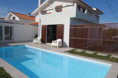 a swimming pool in front of a house at Casa Gaivina 1 in Torreira