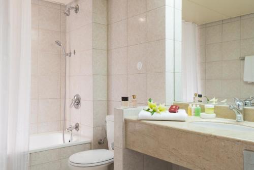 y baño con aseo, lavabo y ducha. en Leonardo Plaza Hotel Eilat en Eilat
