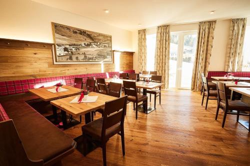 a dining room with wooden tables and chairs at Landhotel Berger in Eben im Pongau