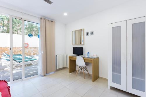 a room with a desk with a computer and a window at Hostal Bonany in Palma de Mallorca