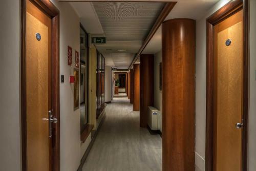 a hallway of a hospital with wooden doors and a hallwayngth at Hotel La Giocca in Rome