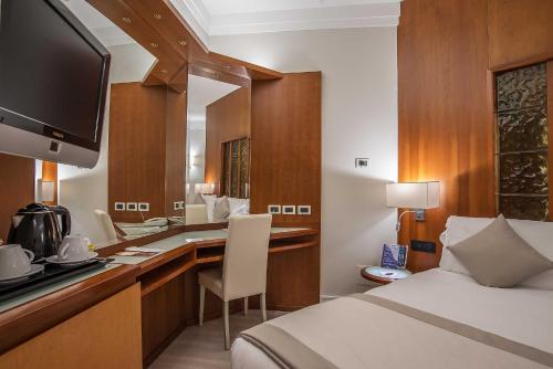 a hotel room with a bed and a desk with a television at Hotel La Giocca in Rome