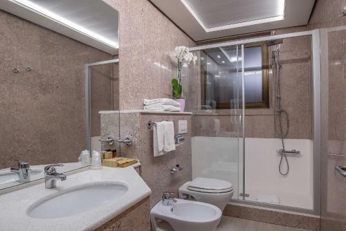 a bathroom with a toilet and a sink and a shower at Hotel La Giocca in Rome