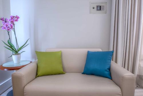 a white couch with two blue and green pillows at Hotel La Giocca in Rome