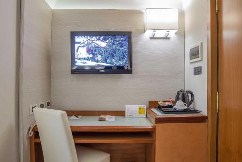 a room with a desk with a television on the wall at Hotel La Giocca in Rome