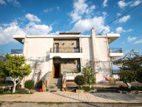 a large white house with stairs in front of it at Paradeisos in Kardamili