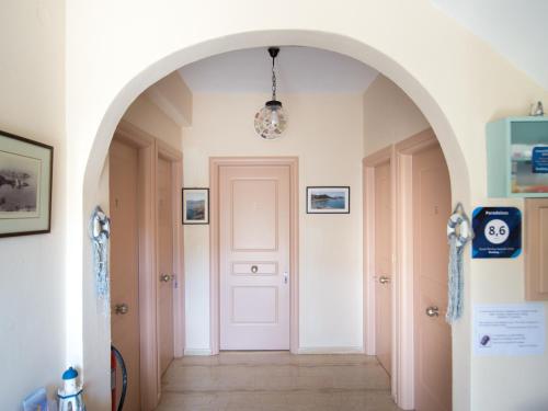 an archway leading into a hallway with a white door at Paradeisos in Kardamili
