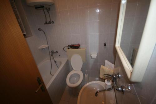a small bathroom with a toilet and a sink at Apartments Cvelic Milovcic in Malinska