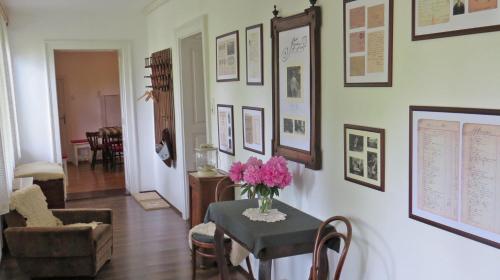 a living room with a table with pink flowers on it at Tarjányi Vendégház in Recsk
