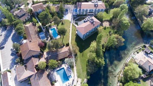 an aerial view of a house with a swimming pool at SOWELL HOTELS Domaine de la Petite Isle in LʼIsle-sur-la-Sorgue