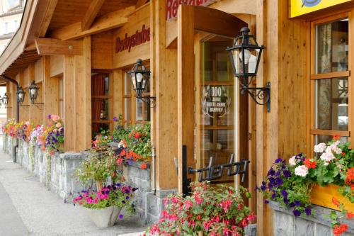 a building with flowers on the side of it at Derby Swiss Quality Hotel in Grindelwald