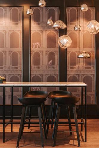 a table and two stools in front of a wall at Best Western Plus Hotel Plaza in Västerås
