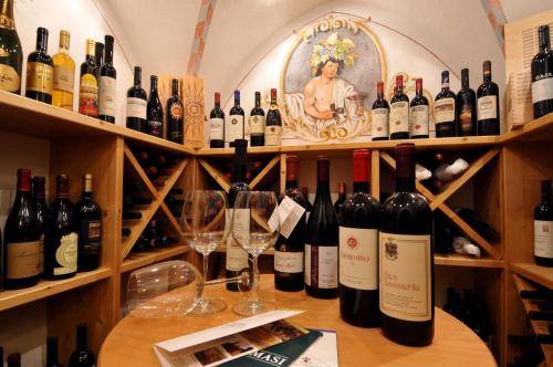 a bunch of wine bottles and glasses on a shelf at Hotel Valacia in Pozza di Fassa