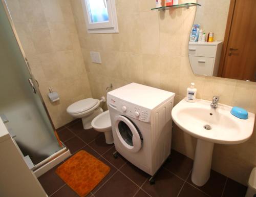 a bathroom with a washing machine and a sink at Summer in Gallipoli