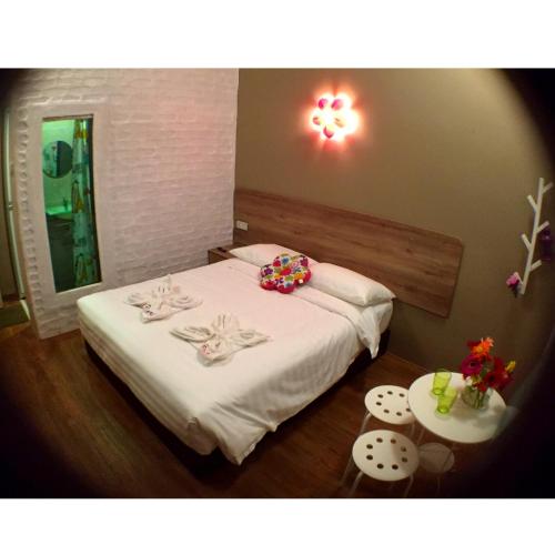 a bedroom with a bed with white sheets and a mirror at Hotel Flora Plus in Cameron Highlands