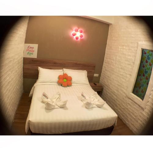a bedroom with a bed with two shoes on it at Hotel Flora Plus in Cameron Highlands