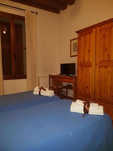 a bedroom with a blue bed and a desk with a computer at Ristorante Pizzeria al Mondo in Valstagna