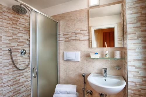un bagno con lavandino e doccia di Hotel Barca D'Oro a Bellaria-Igea Marina
