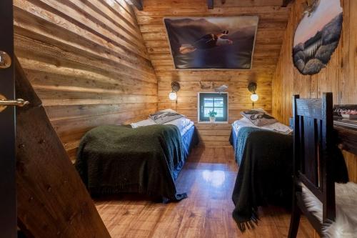a room with two beds in a log cabin at J A Ranch Bed & Breakfast in Strömsnäsbruk