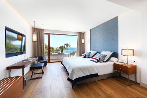 a bedroom with a bed and a desk and a window at Hotel Son Caliu Spa Oasis in Palmanova
