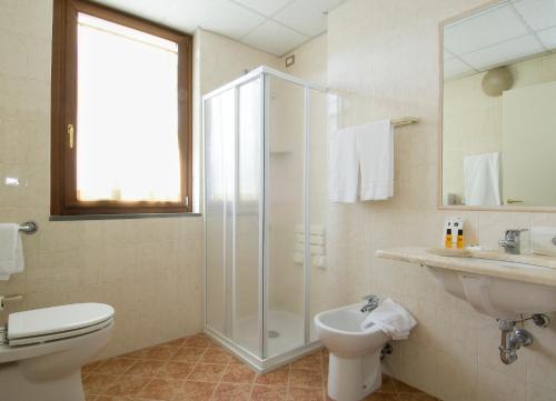 a bathroom with a shower and a toilet and a sink at Hotel Palazzo dei Priori in Siena