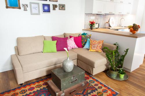 sala de estar con sofá y almohadas coloridas en Self checkin bohem luxury by Váci str, en Budapest
