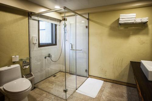 a bathroom with a shower and a toilet and a sink at Oasis Hotel in Magong