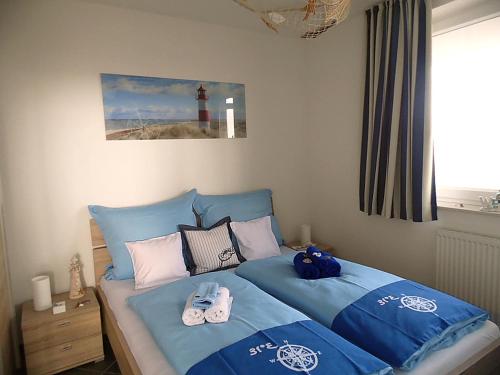 ein Schlafzimmer mit einem Bett mit blauer Bettwäsche und einem Leuchtturm in der Unterkunft Apartment Leuchtturm 16 in Großenbrode