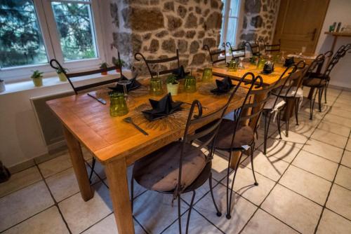 a long wooden table with chairs in a room at Loire-Gerbier-Mézenc in Sainte-Eulalie