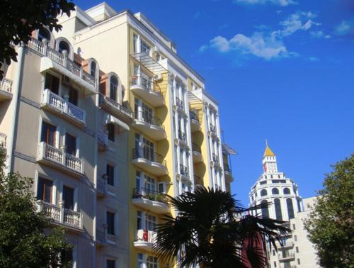 a tall building with a tower in the background at Apartments in the Center of Batumi in Batumi