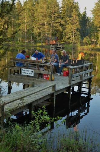 a group of people sitting at a picnic table on a dock at Tivedens Hostel-Vandrarhem in Karlsborg