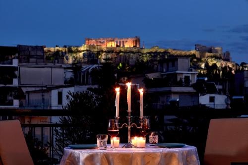 a table with candles on it with a castle in the background at 18 Micon Str. in Athens