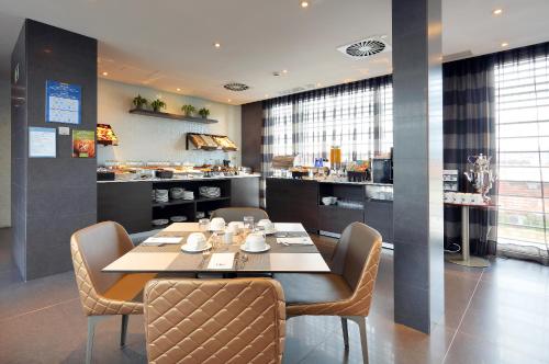 a dining room with a table and chairs and a kitchen at Eurostars Plaza Mayor in Madrid