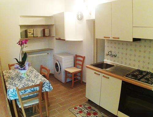 a kitchen with a table and a small kitchen with a stove at La Mimosa in Forte dei Marmi