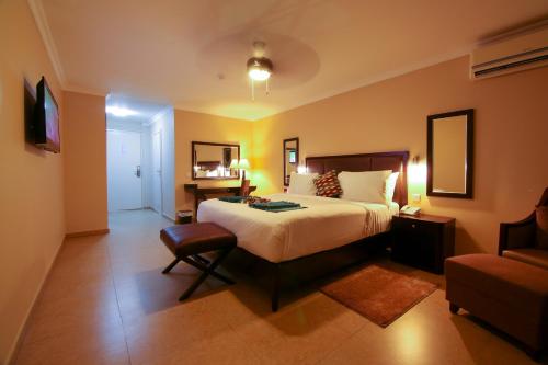 a hotel room with a bed and a chair at Best Western Plus Accra Beach Hotel in Teshi