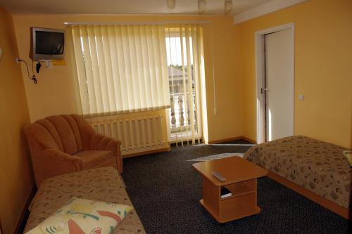 a hotel room with a bed and a chair at Turnė Guest House in Šiauliai