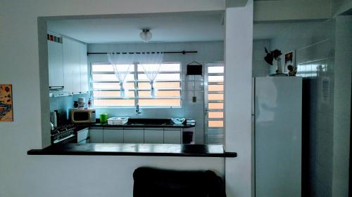 a kitchen with a white refrigerator and a window at Casa Matinhos Caioba Parana in Matinhos