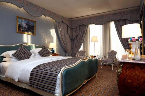 um quarto com uma cama grande num quarto com cortinas em InterContinental Taif, an IHG Hotel em Taif