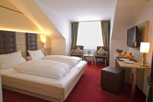 ein Hotelzimmer mit einem Bett und einem TV in der Unterkunft Belchenhotel Jägerstüble in Aitern