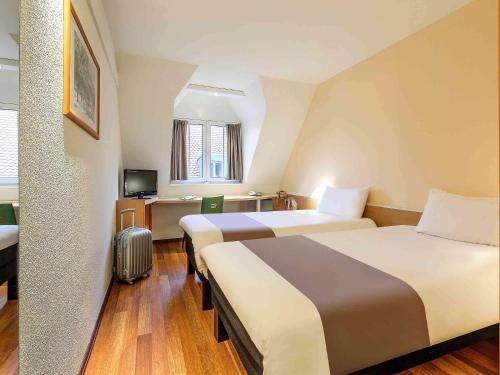 a hotel room with two beds and a television at ibis Hotel Erfurt Altstadt in Erfurt