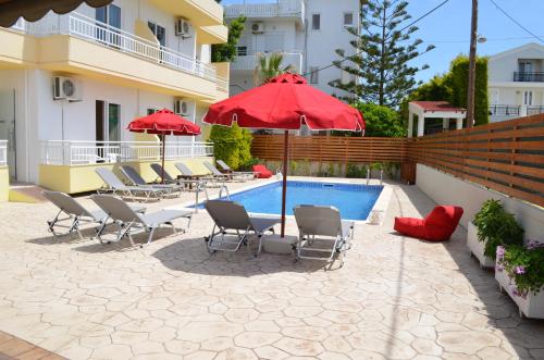 un patio con sillas y sombrillas junto a una piscina en Kremasti Memories, en Kremasti
