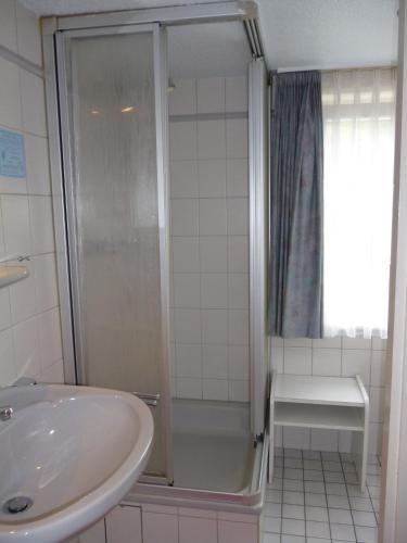 a bathroom with a shower and a sink at Hotel-Café-Restaurant Parkhaus in Altenau