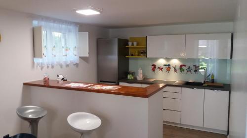 a kitchen with white cabinets and a counter with stools at Garden apartment Vanya in Split