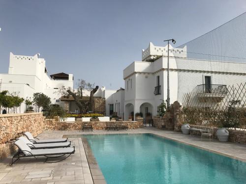 a swimming pool in front of a white building at Masseria Le Mandorle in Ugento