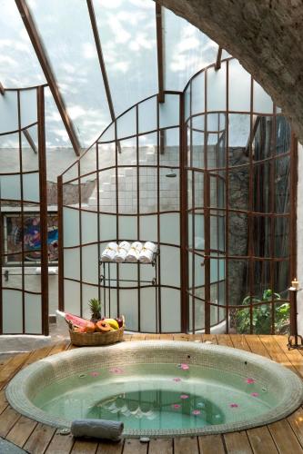 a hot tub on a wooden deck with a balcony at Hacienda San Gabriel de las Palmas in Amacuzac