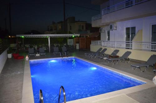 una piscina por la noche con sillas alrededor en Kremasti Memories, en Kremasti