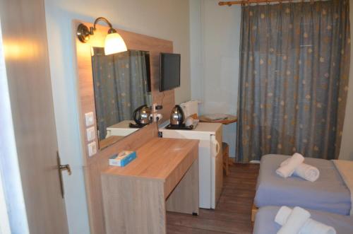 ポルト・ヘリにあるRozos Hotelのデスク、テーブル、デスクが備わる小さな客室です。
