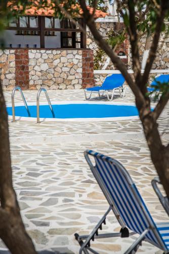 a blue chair sitting next to a swimming pool at Hotel Olympia in Karterados